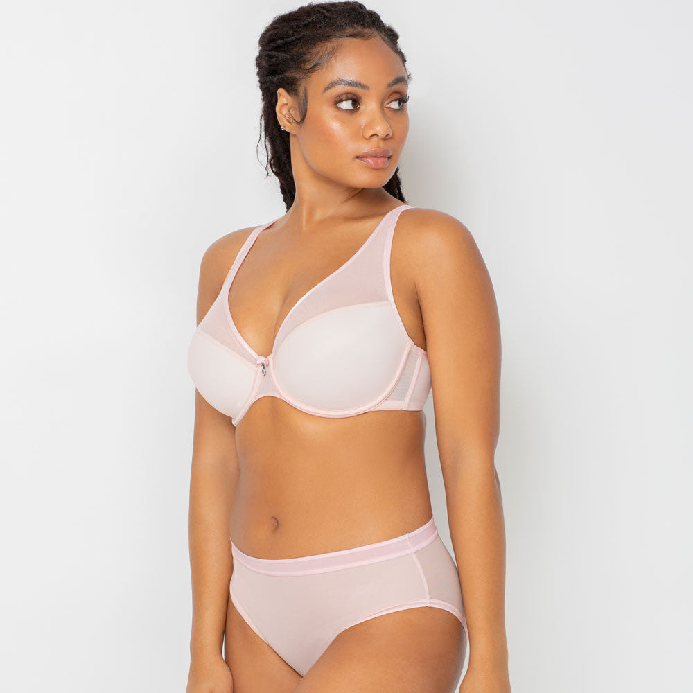 Woman wearing a light pink bra and underwear set on a white background