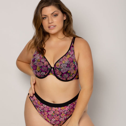 Woman wearing a floral lingerie set against a plain background