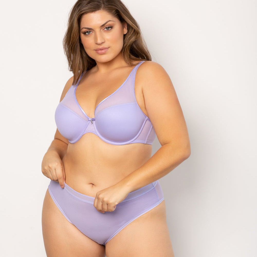 Woman wearing a lavender bra and underwear set on a plain background