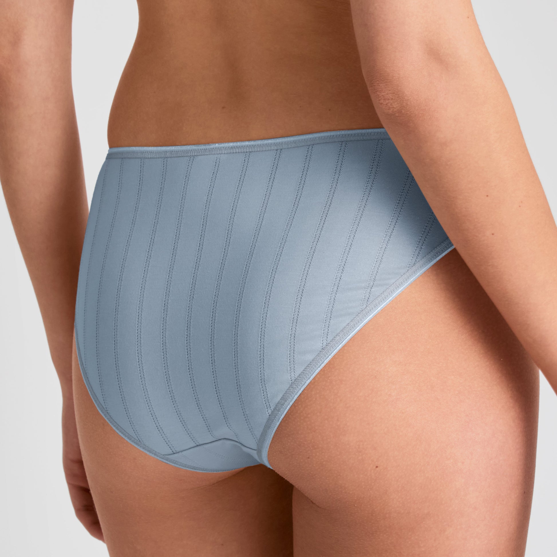 Light blue underwear worn by a person on a plain background