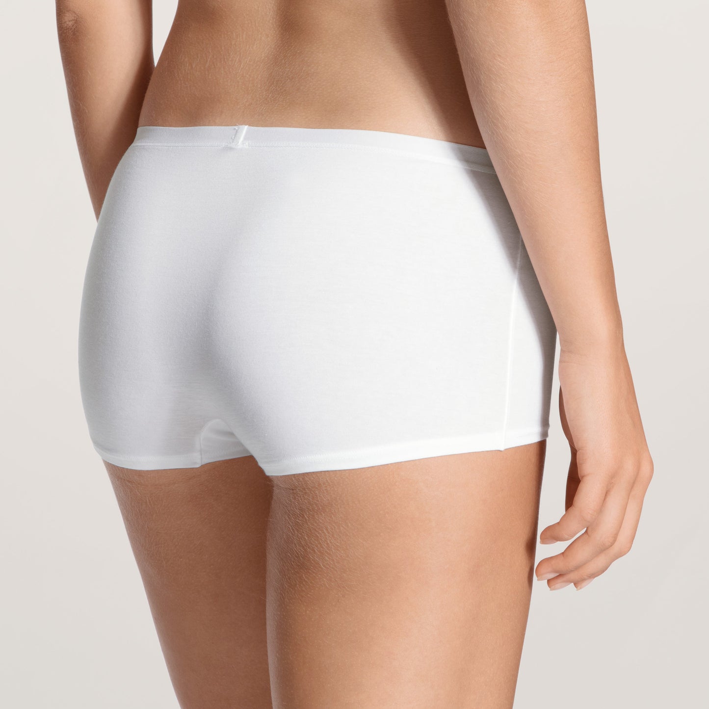 White underwear worn by a person on a light gray background
