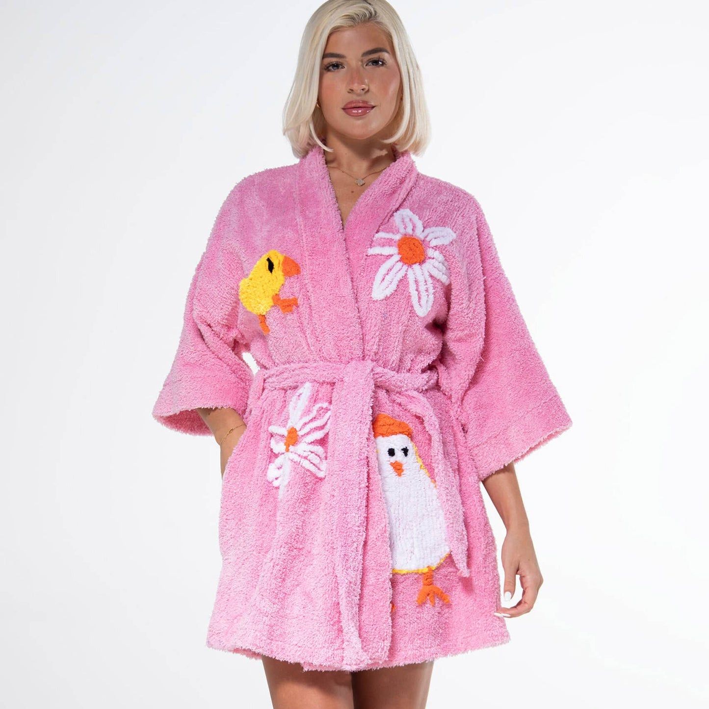 Person wearing a pink robe with cartoon character designs on a white background