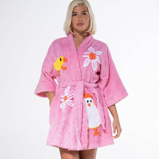Person wearing a pink robe with cartoon character designs on a white background