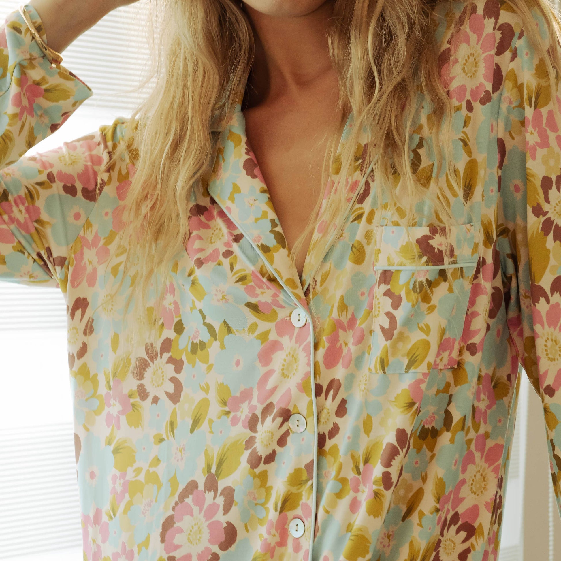 Person wearing a floral patterned nightshirt in a bright room.