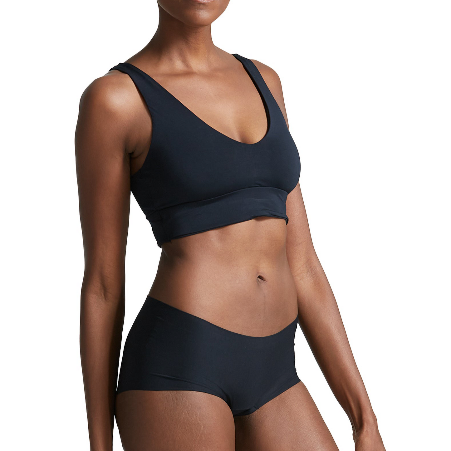 Person wearing a black bralette and shorts on a white background