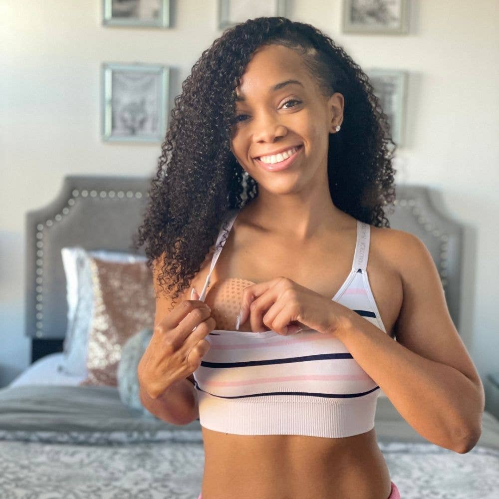 Woman wearing a striped sports bra in a bedroom setting