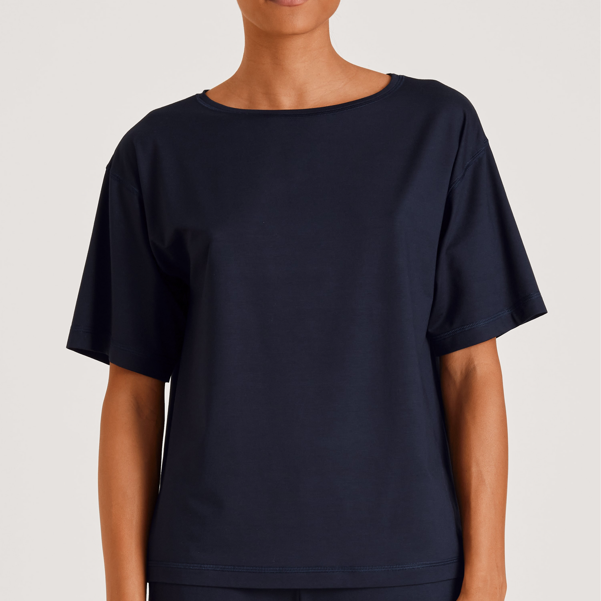 Person wearing a navy blue t-shirt on a plain background