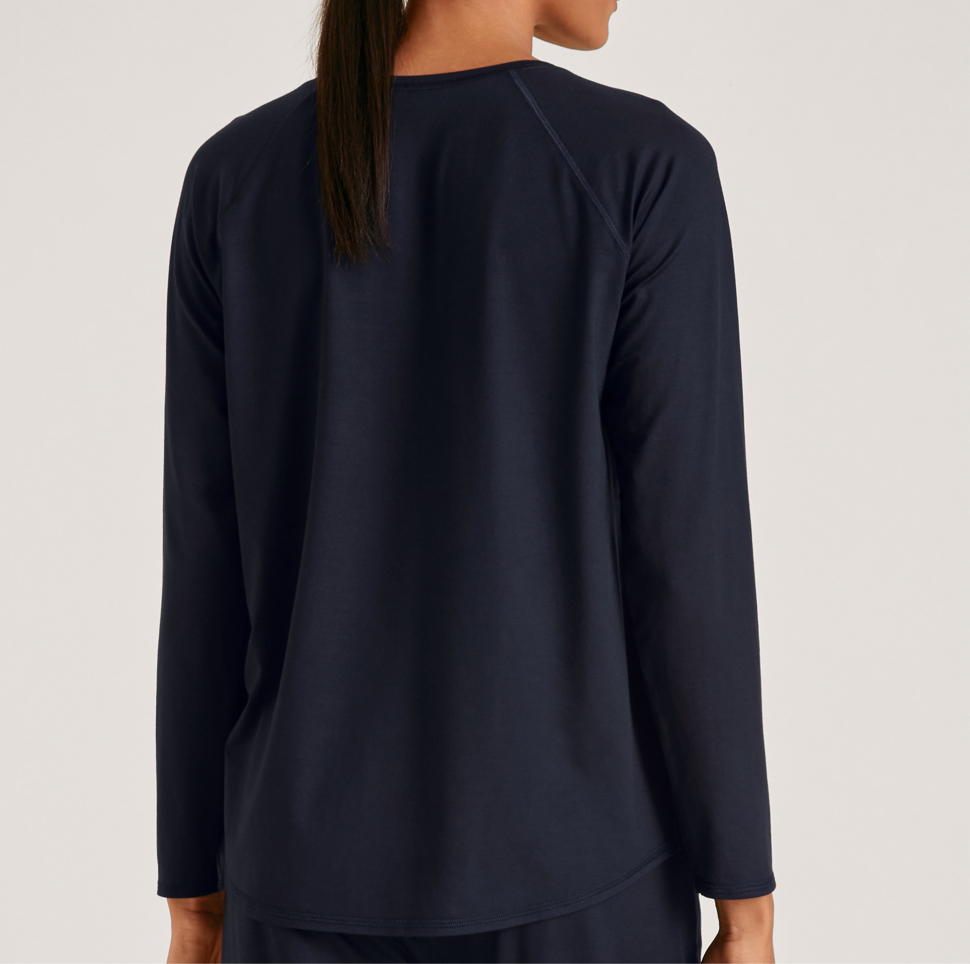 Navy long-sleeve shirt worn by a person on a light gray background