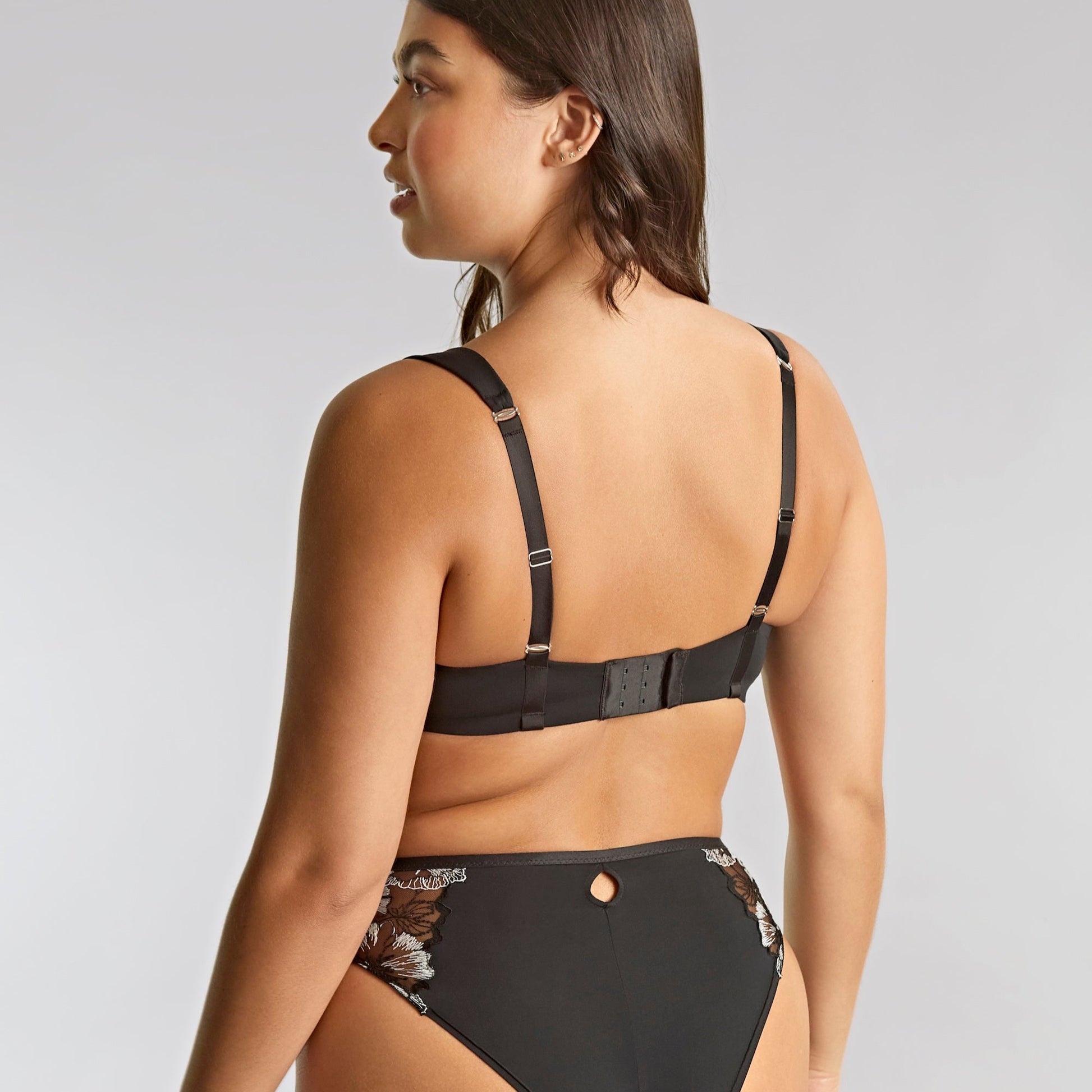 Woman wearing a black bikini with a plain background