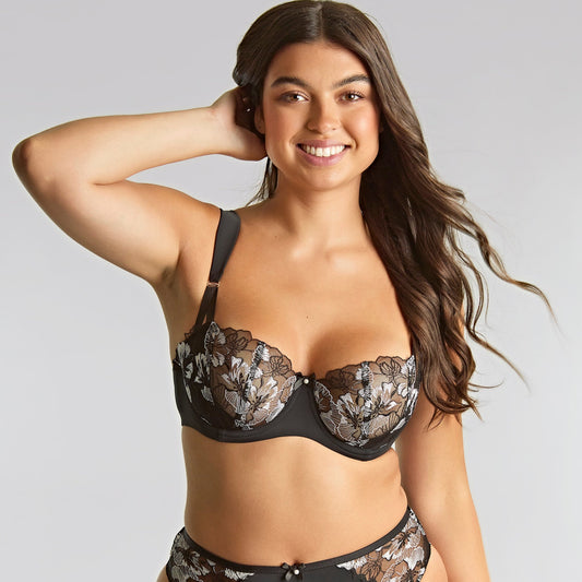 Woman wearing a black lace bikini on a plain background