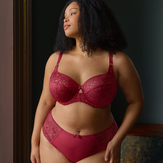Woman wearing a red bra and panties set against a dark background