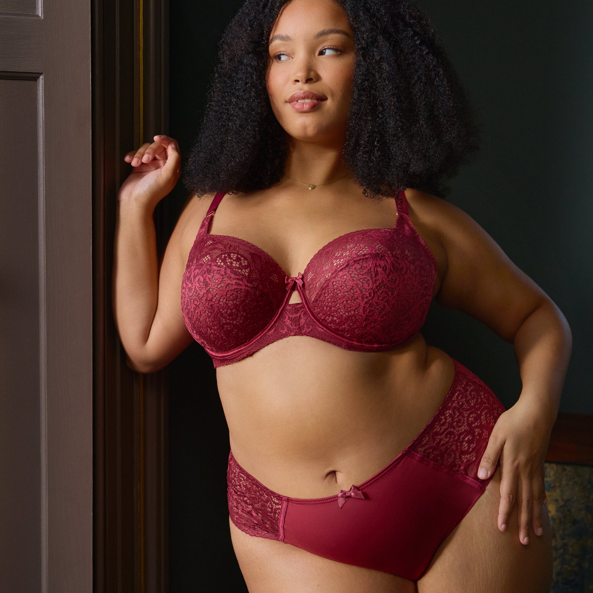 Woman wearing a red bra and panties set against a dark background