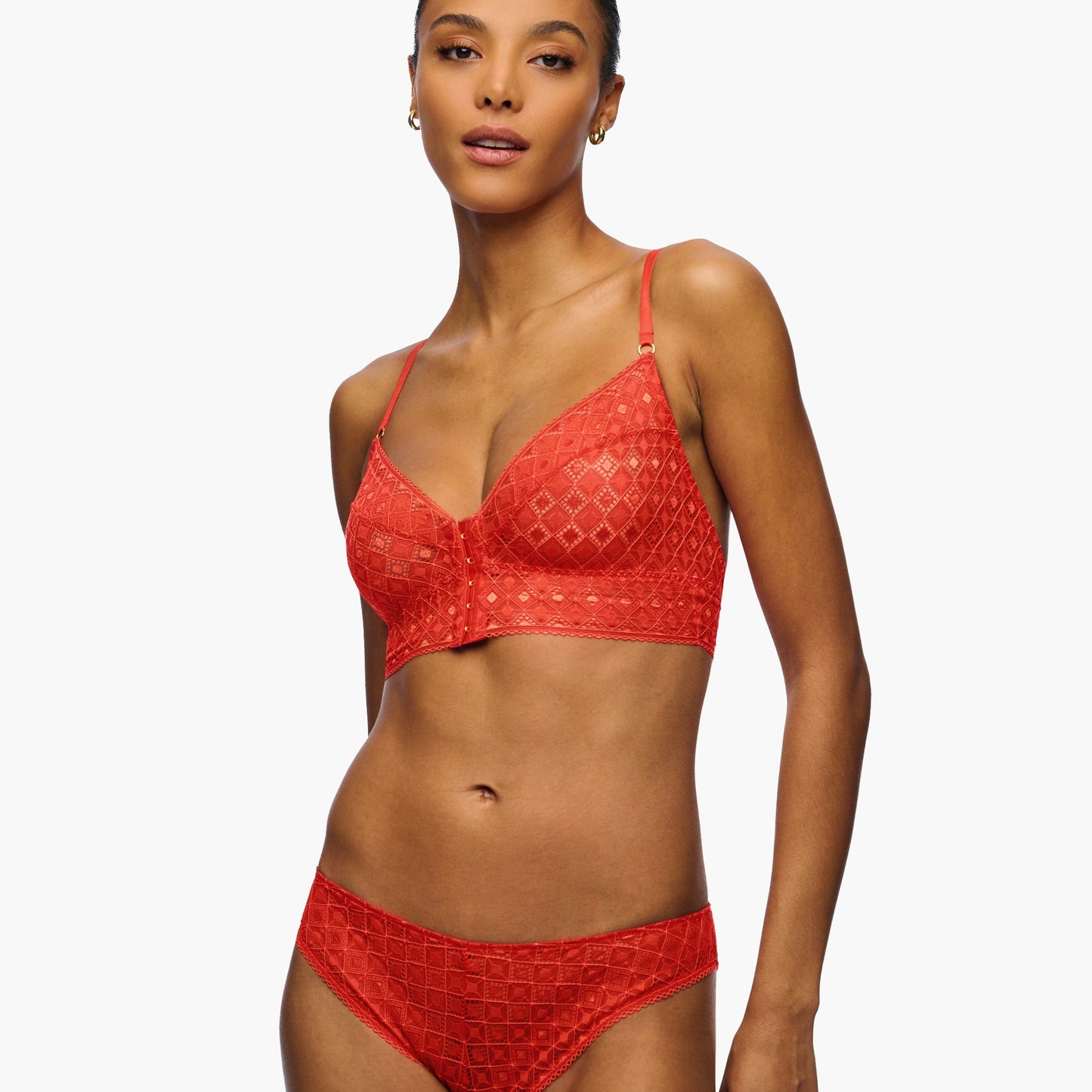 Woman wearing a red lace bikini against a white background