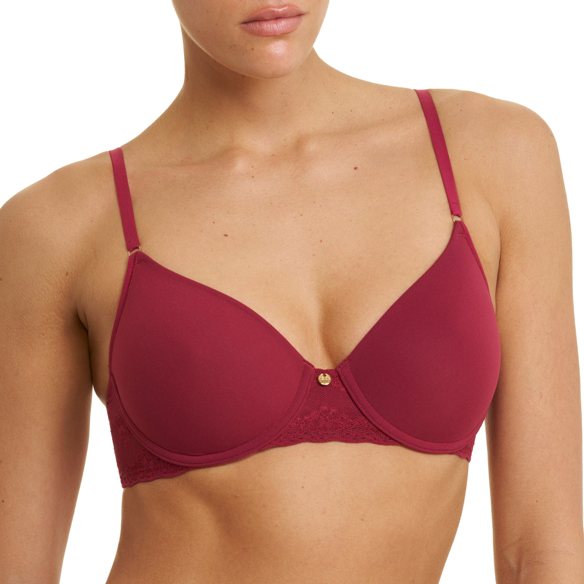 A woman wearing a deep burgundy underwire bra with thin adjustable straps and a small gold button at the center, shown against a plain white background.