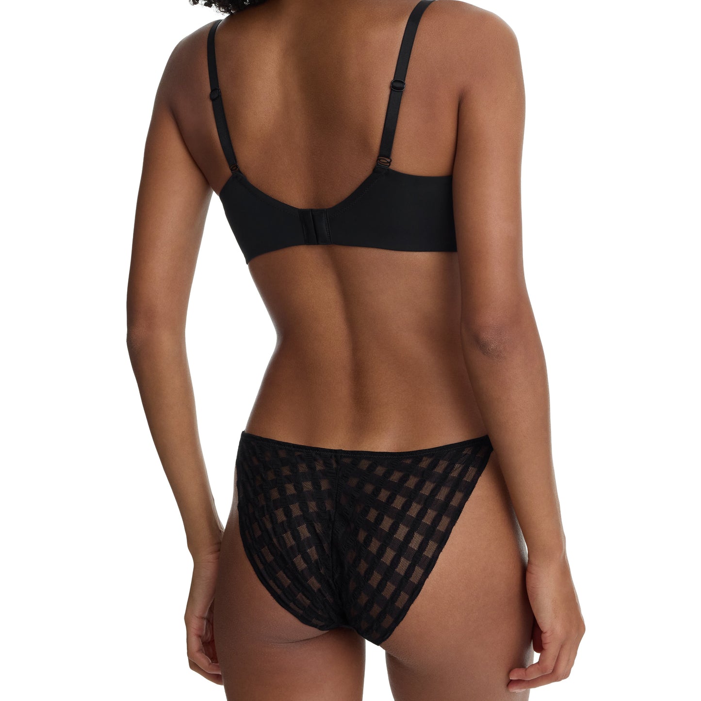 Woman wearing a black bikini with mesh details on a white background