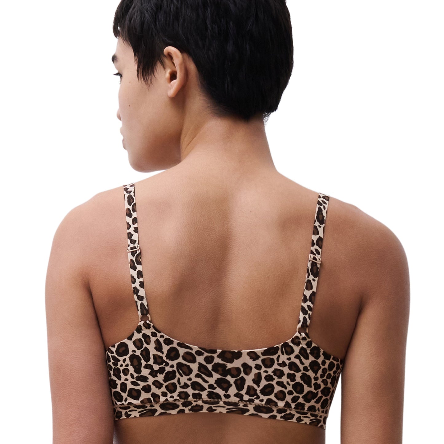 Person wearing a leopard print bra on a white background