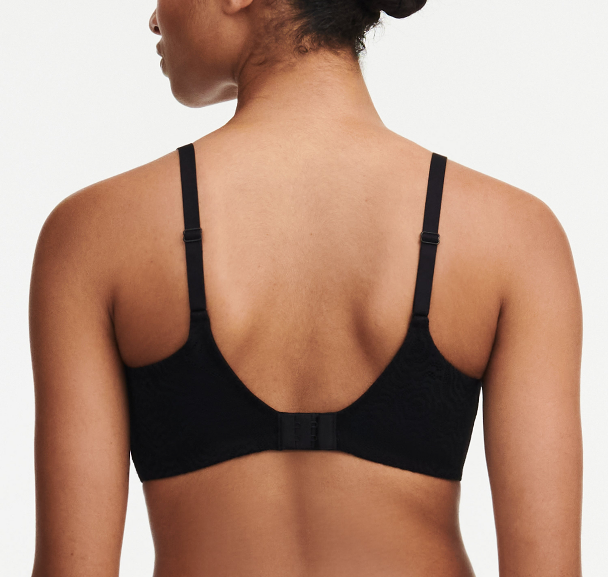 Black bra worn by a person on a plain background