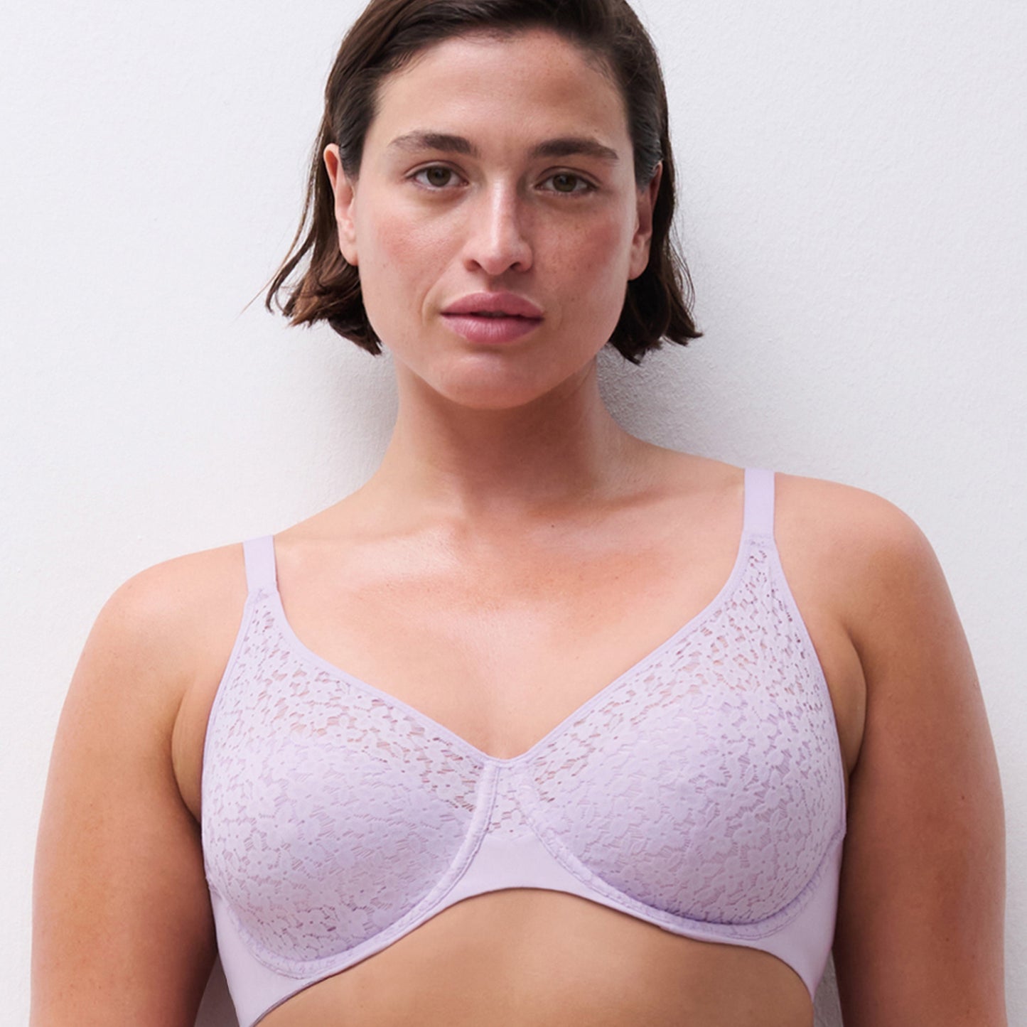 Woman wearing a light purple bra against a plain background