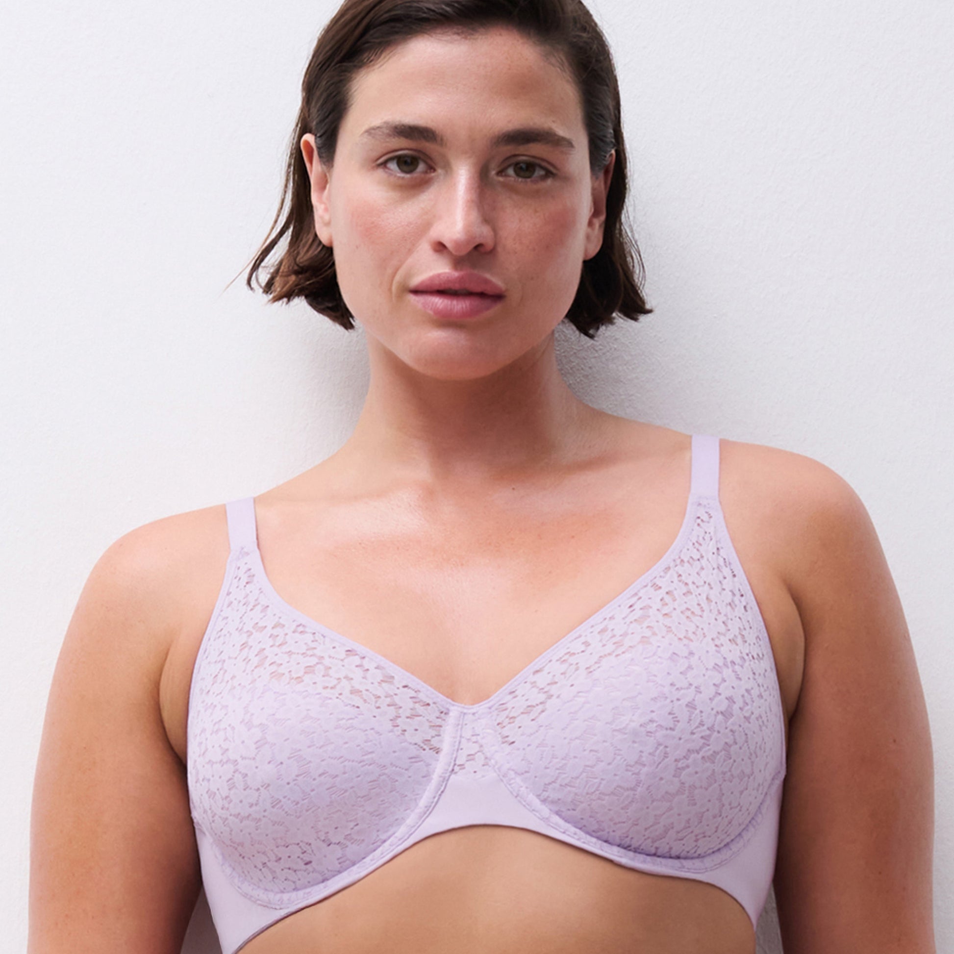 Woman wearing a light purple bra against a plain background