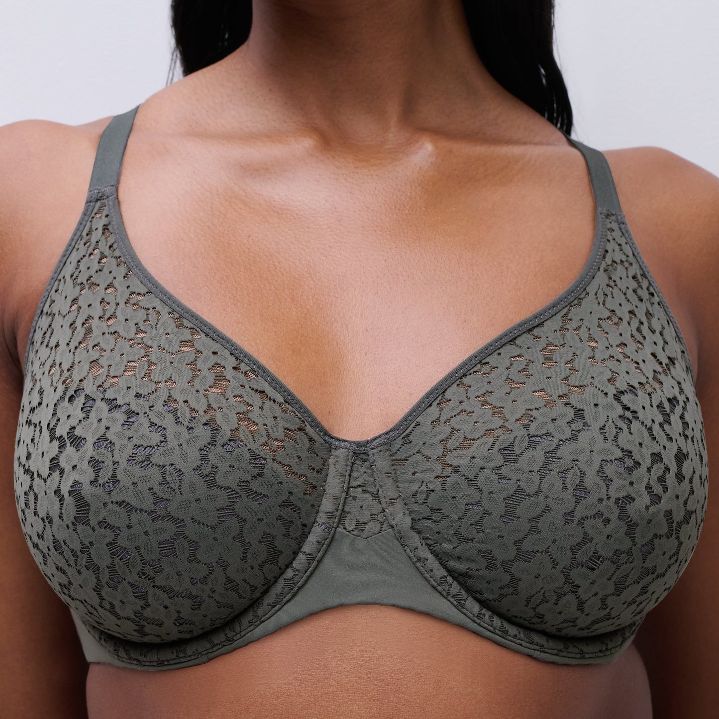 Green patterned bra worn by a person on a plain background