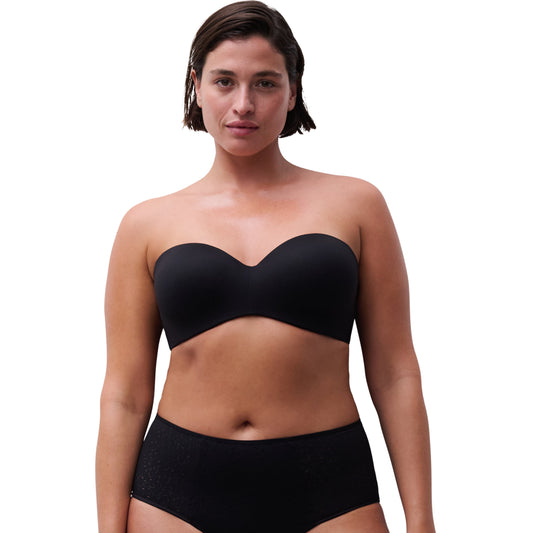 Woman wearing a black strapless top and high-waisted bikini bottom on a white background