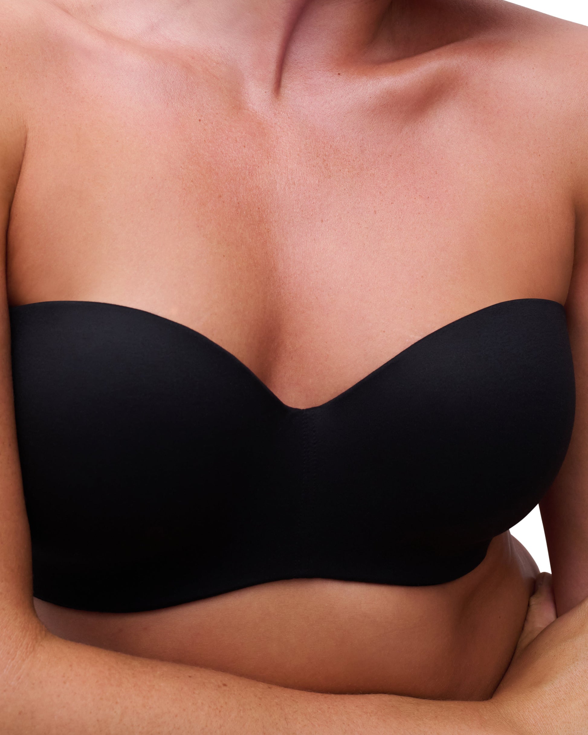 Black strapless bra worn by a person on a white background