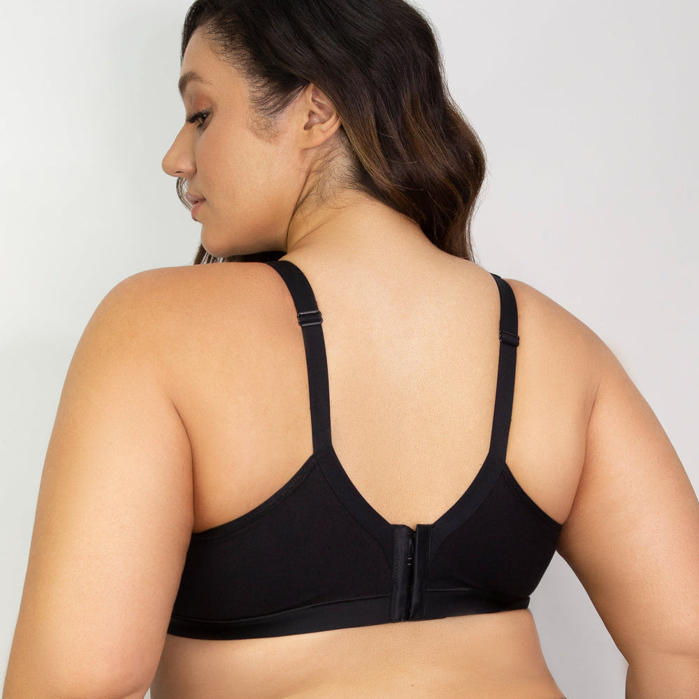 Woman wearing a black sports bra against a plain background