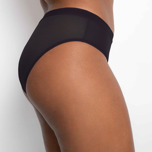 Black underwear worn by a person on a light gray background
