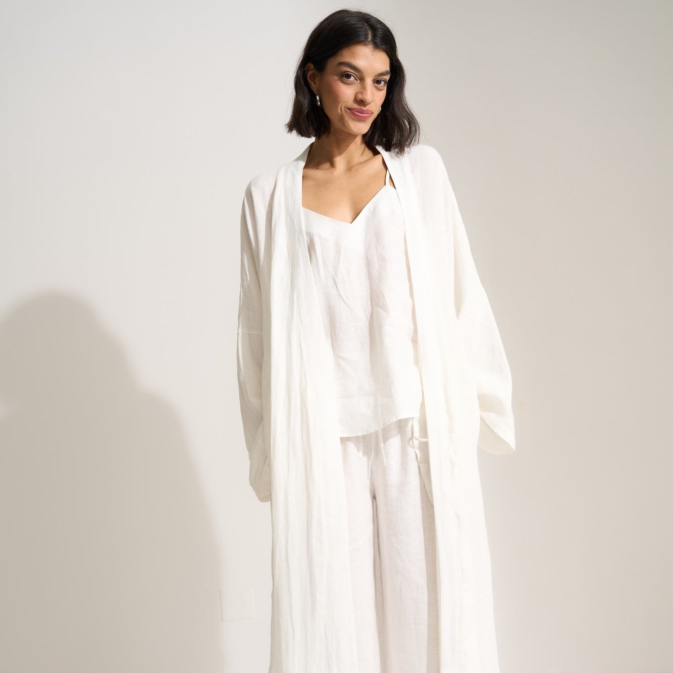 Woman wearing a white outfit against a plain background