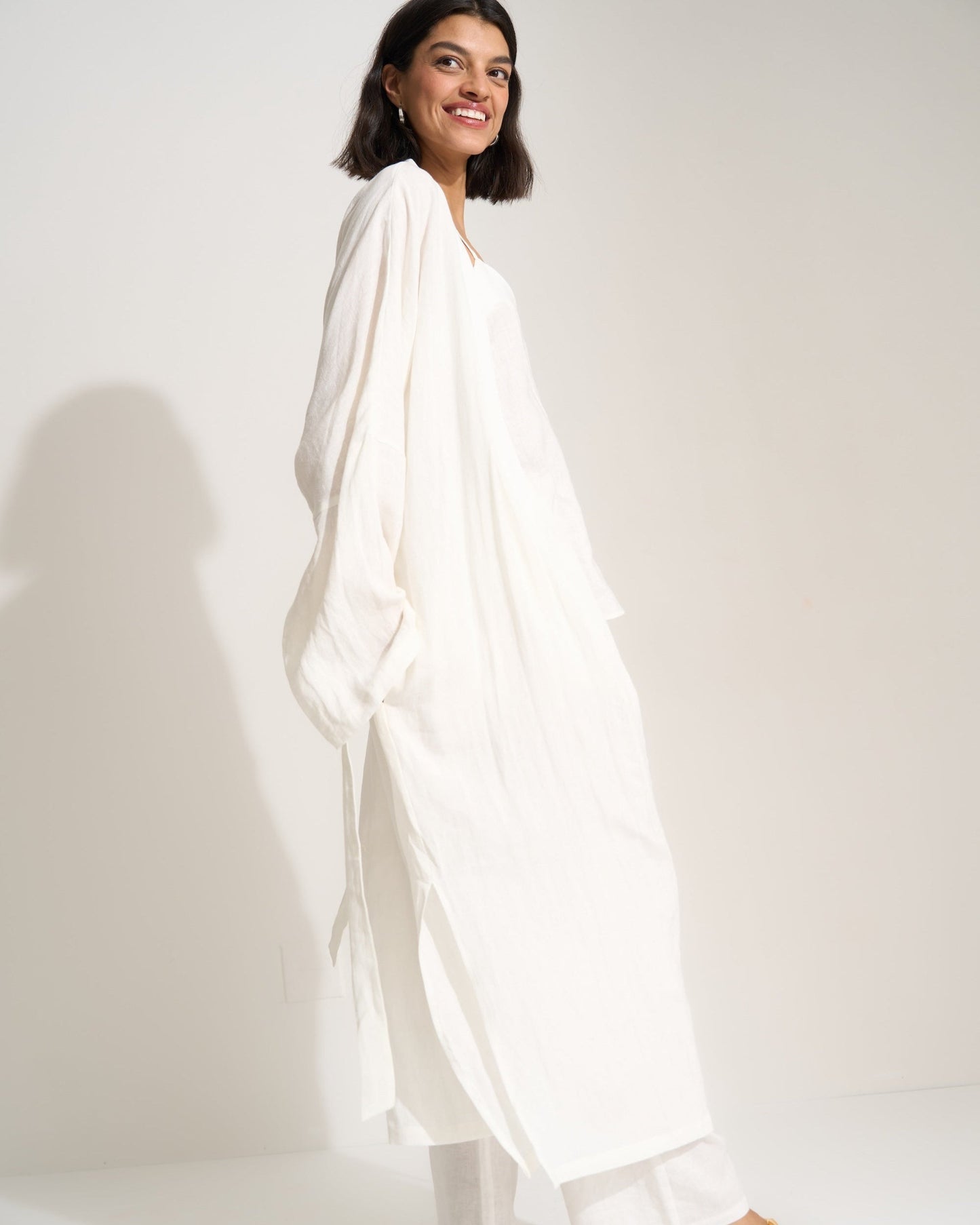 Woman wearing a white outfit on a plain background