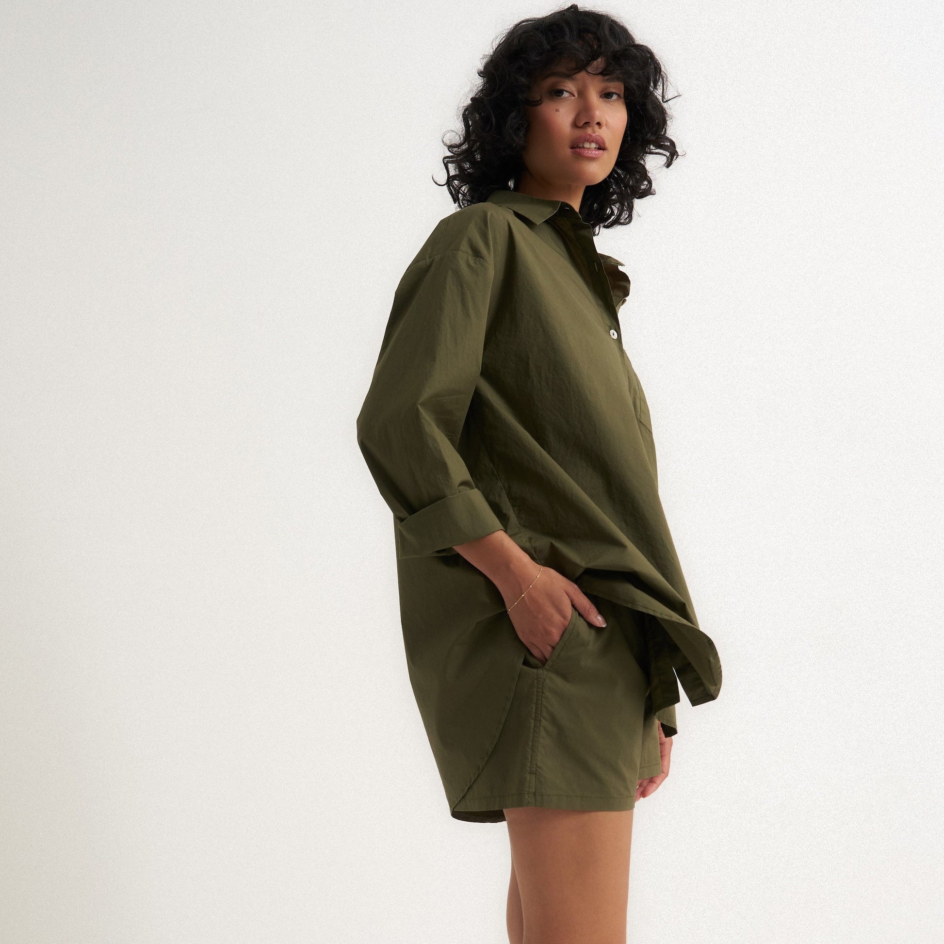 Woman wearing a green set against a white background