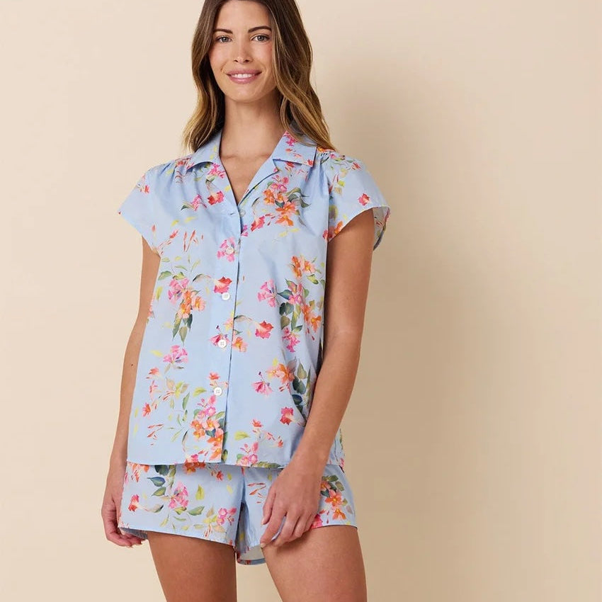 Woman wearing a floral pajama set against a beige background