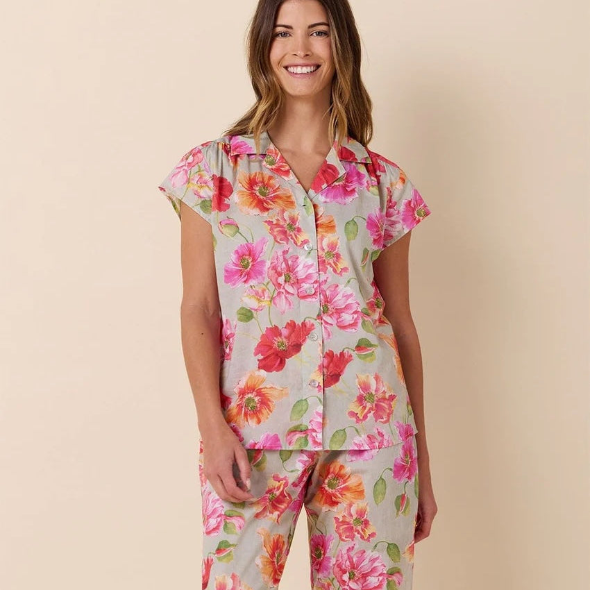 Woman wearing a floral pajama set on a beige background