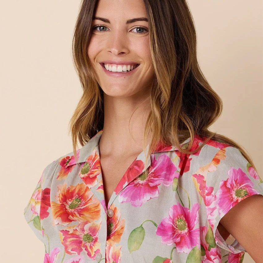 Woman wearing a floral shirt against a beige background