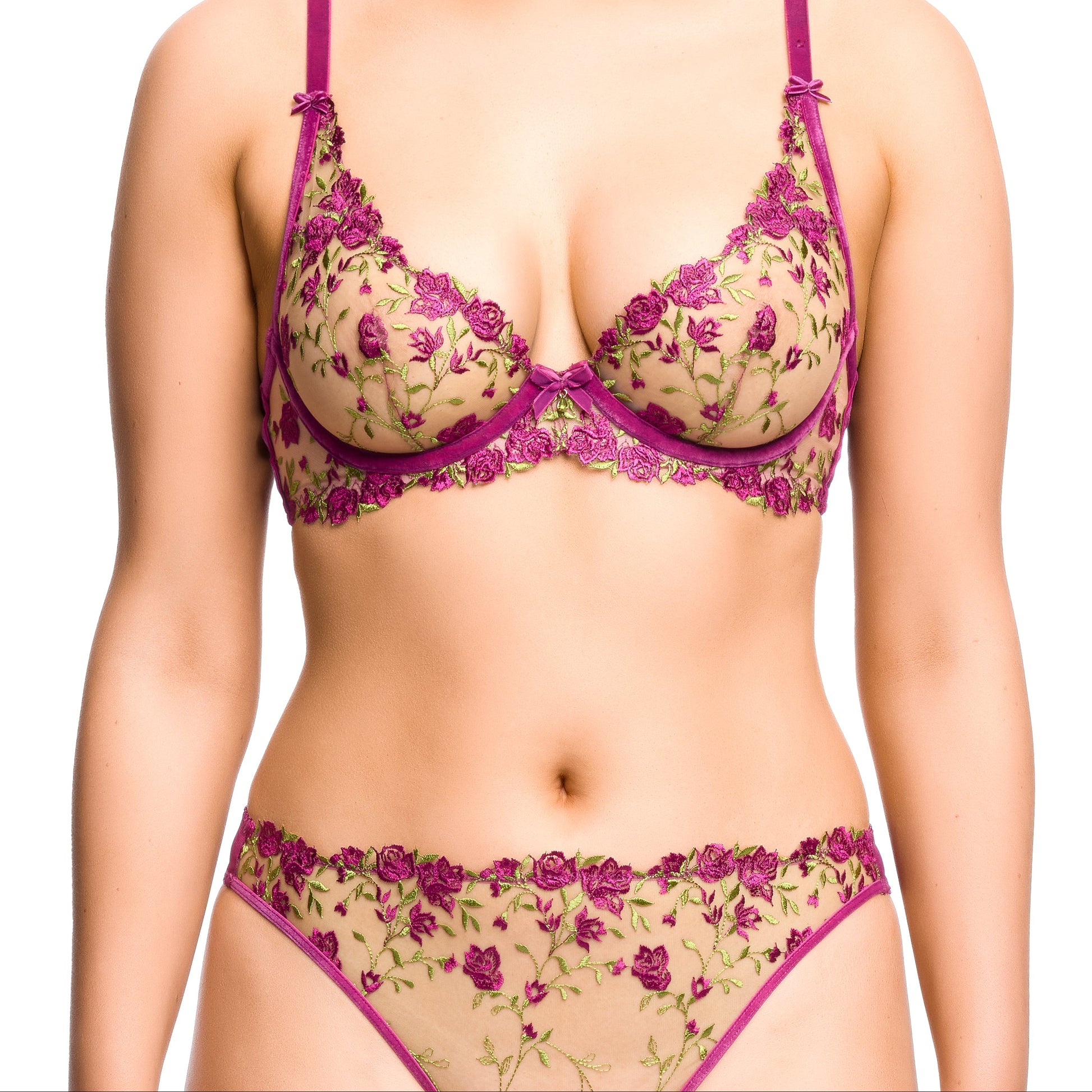 Woman wearing a floral lingerie set with a purple trim on a white background
