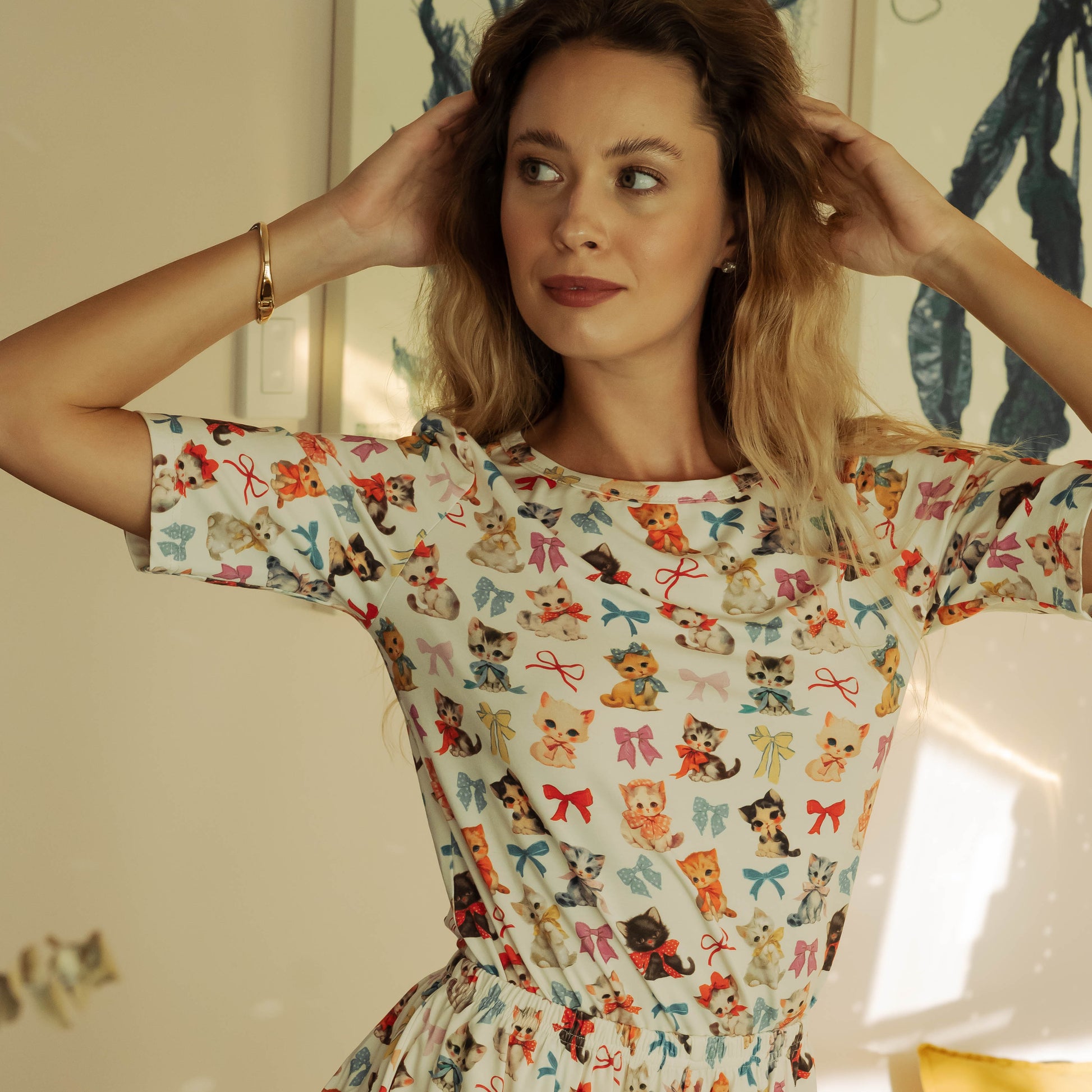 Woman wearing a colorful patterned dress indoors with a neutral background