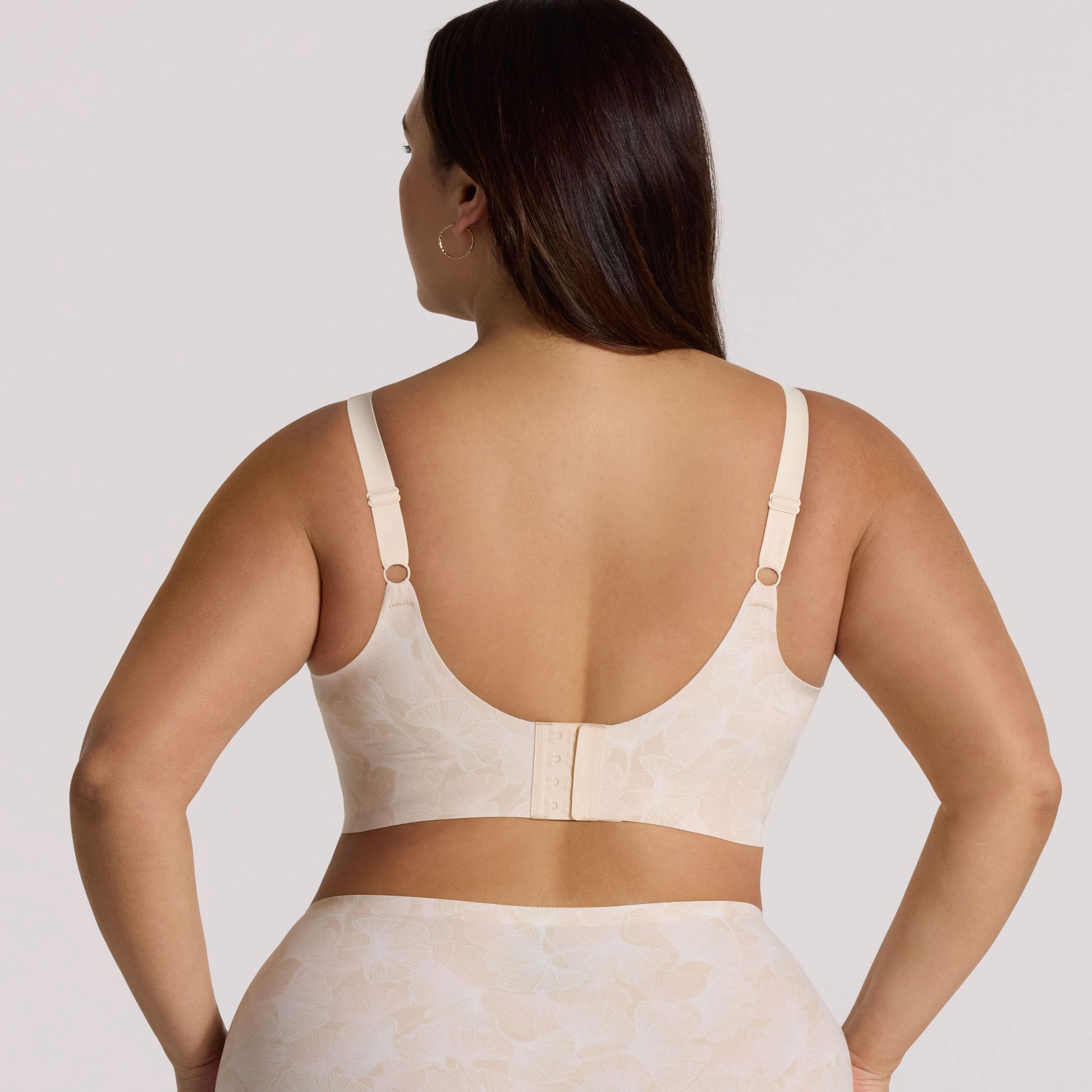 Woman wearing a beige compression garment against a plain background