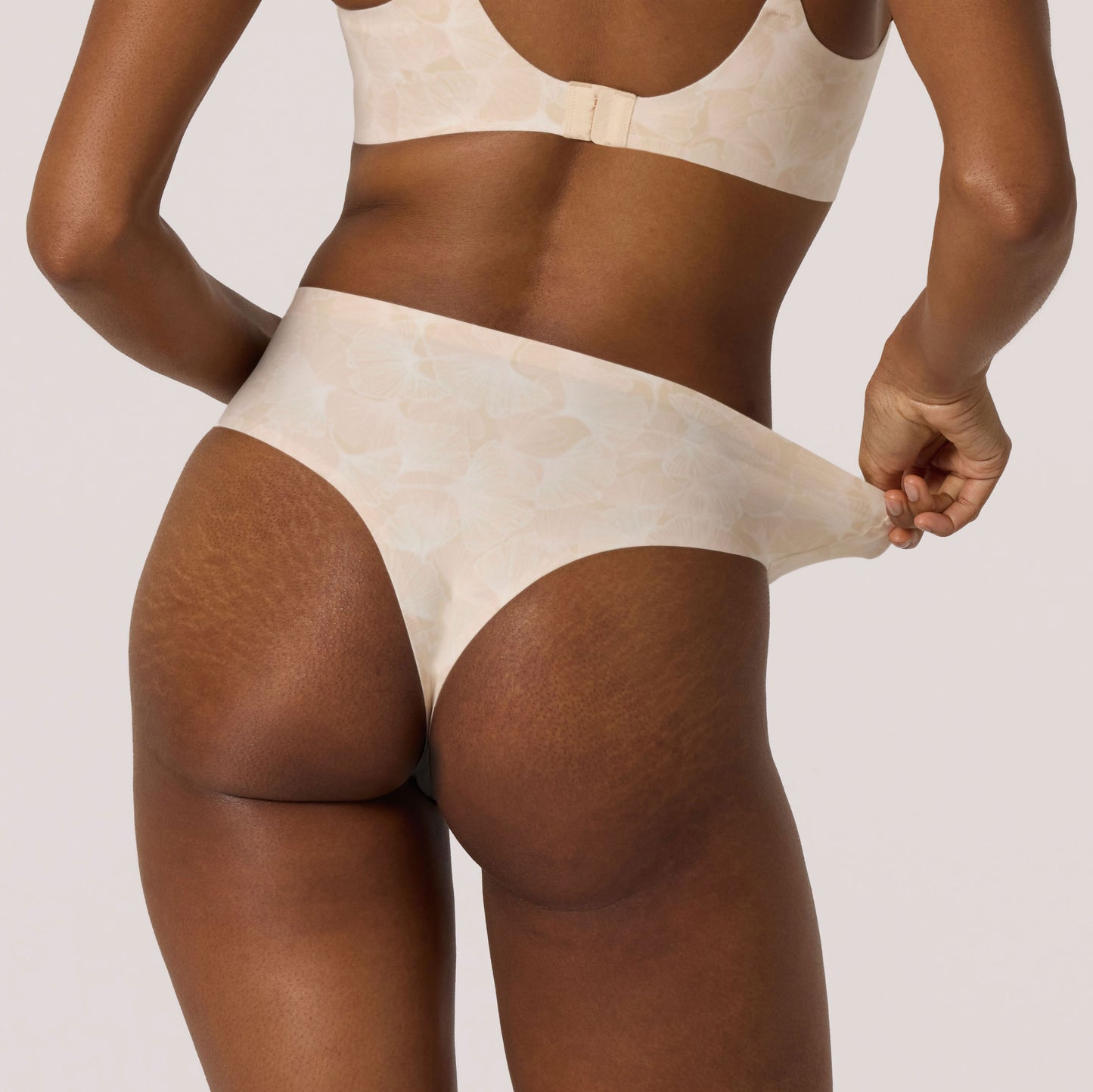 Beige underwear worn by a person on a plain background