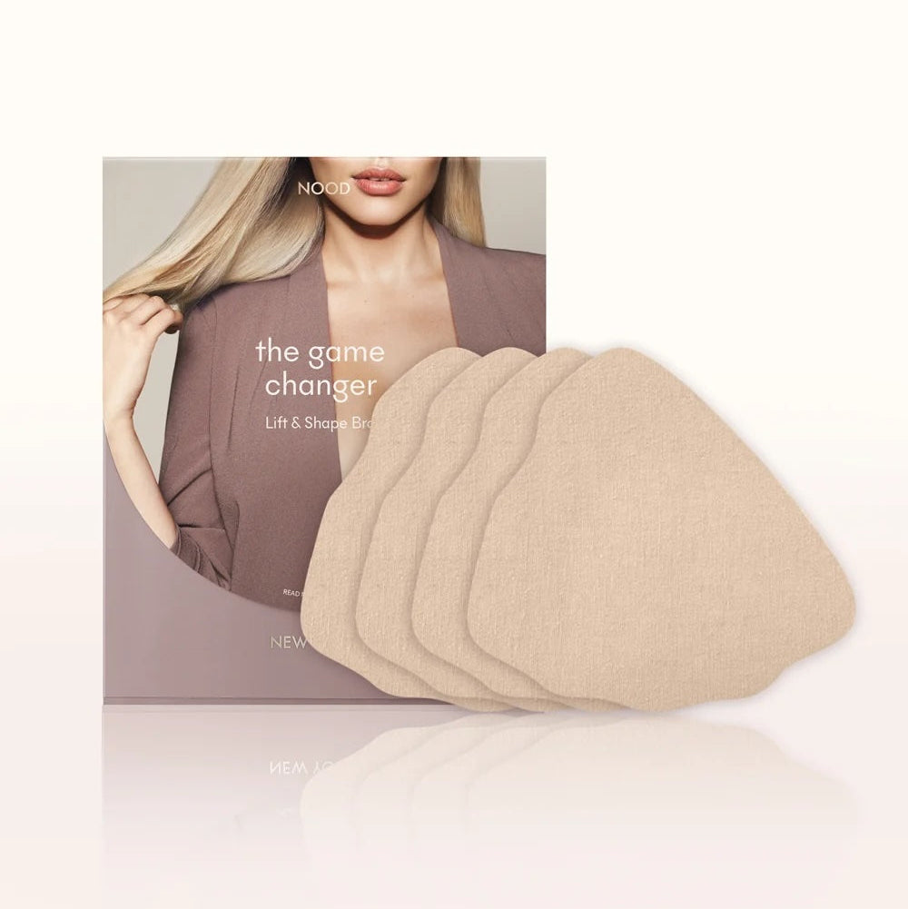Six beige fabric lift and shape pads fanned out in front of their product packaging box, which features a blonde model wearing a mauve blazer. The brand name 'NOUO' is visible on the box.