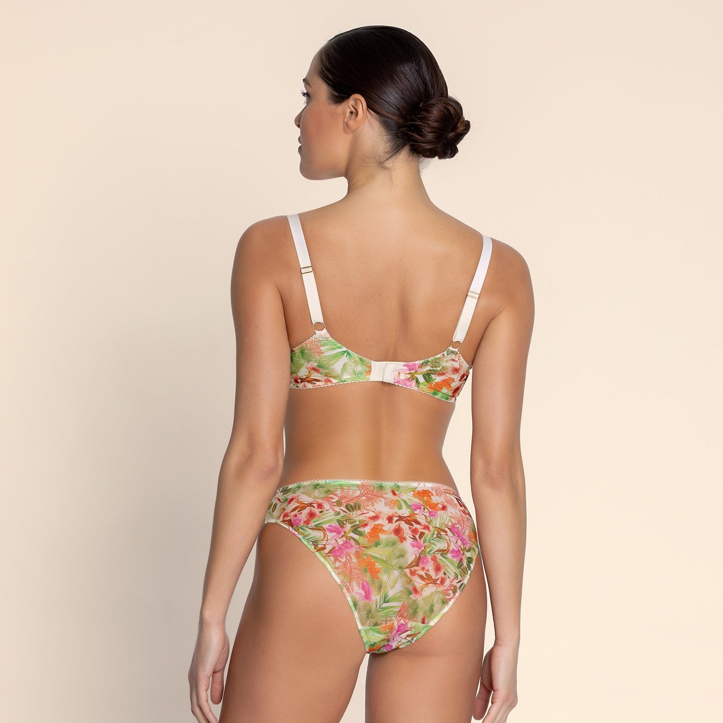Woman wearing a floral bikini set on a beige background
