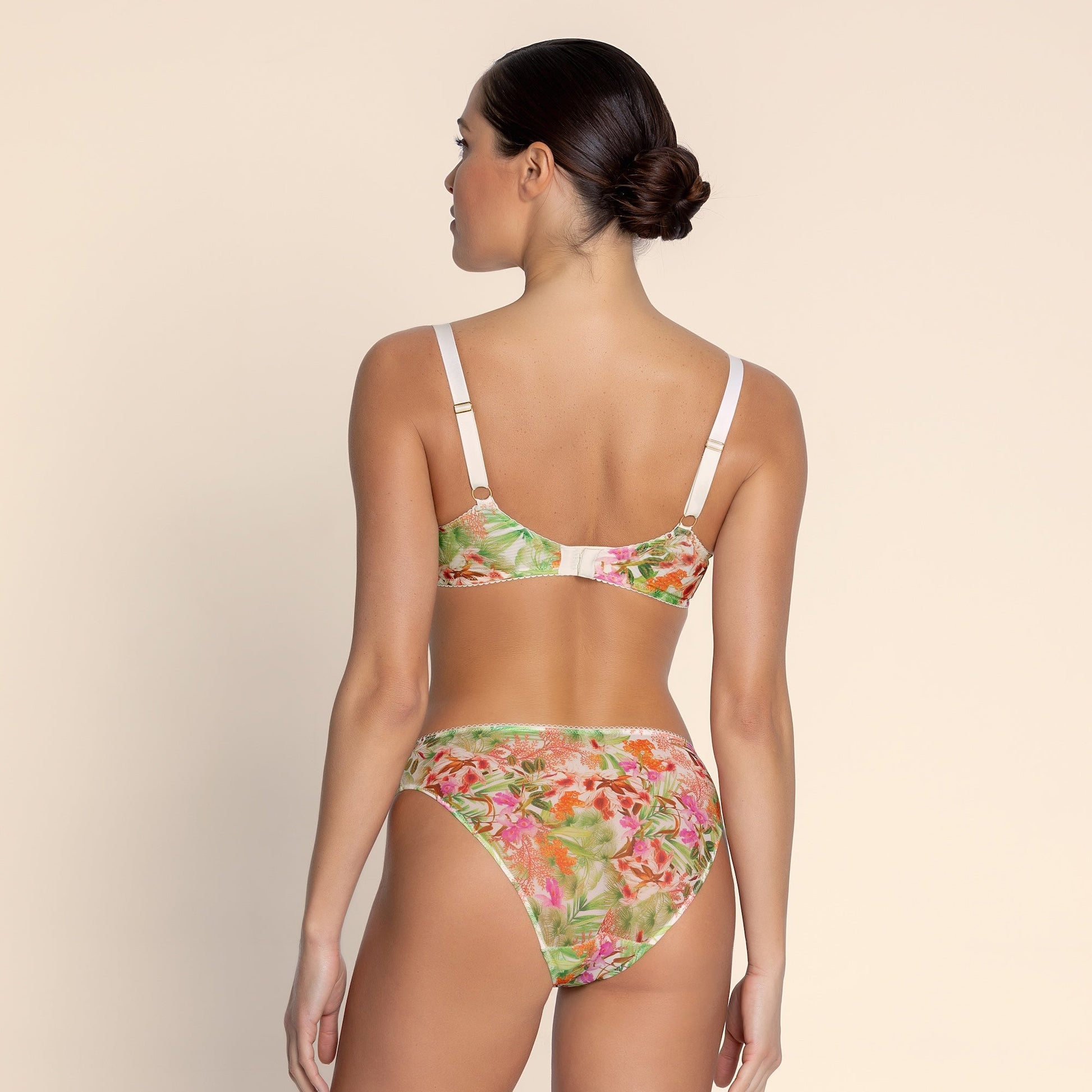 Woman wearing a floral bikini set on a beige background