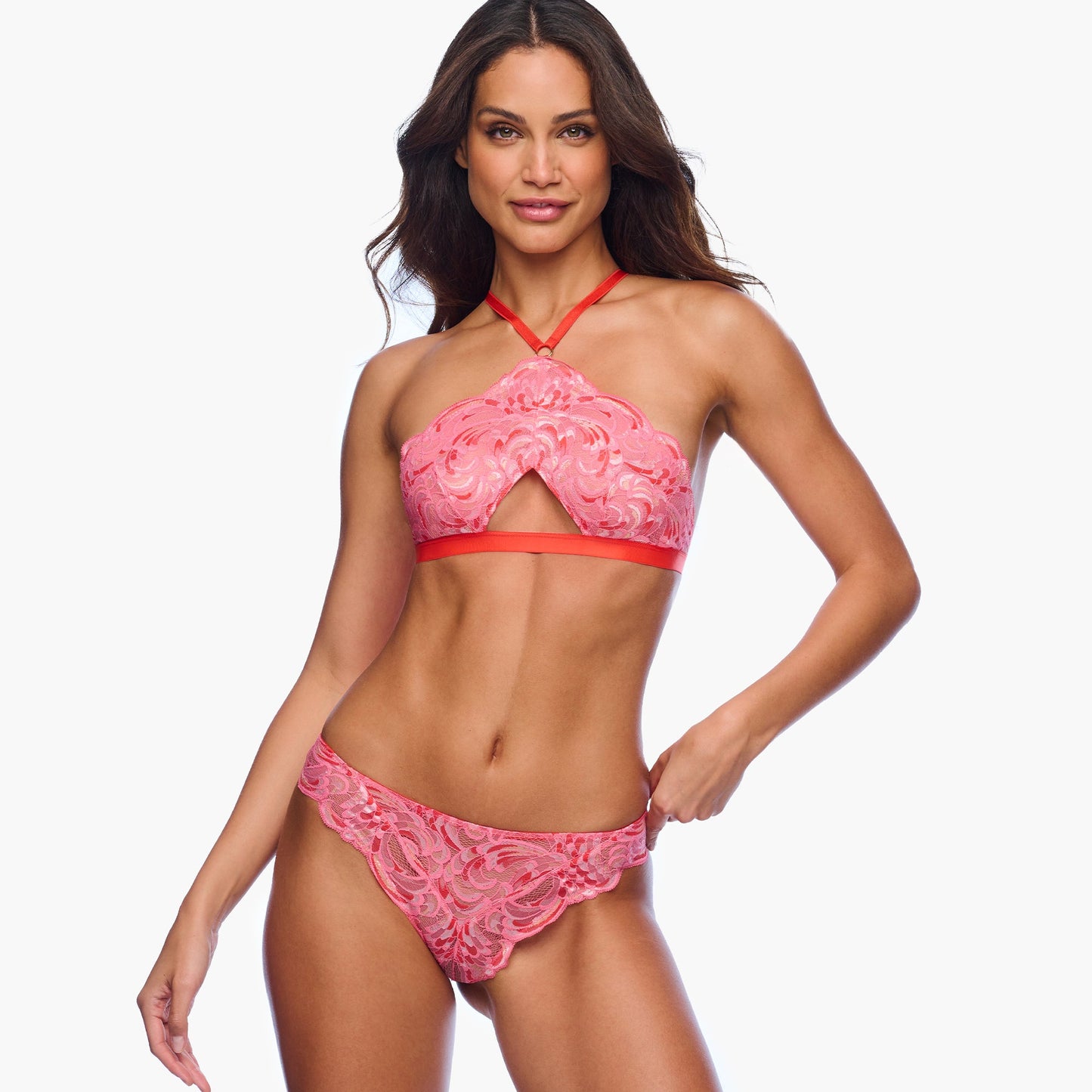 Woman wearing a pink lace lingerie set on a white background