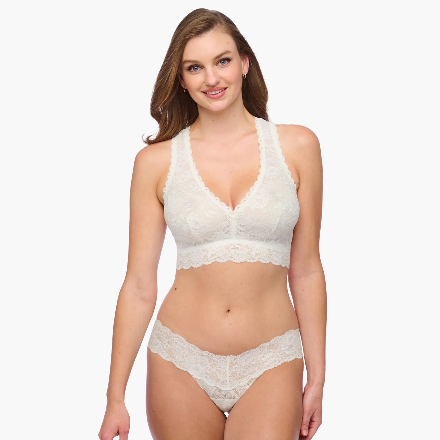 Woman wearing a white lace lingerie set on a white background
