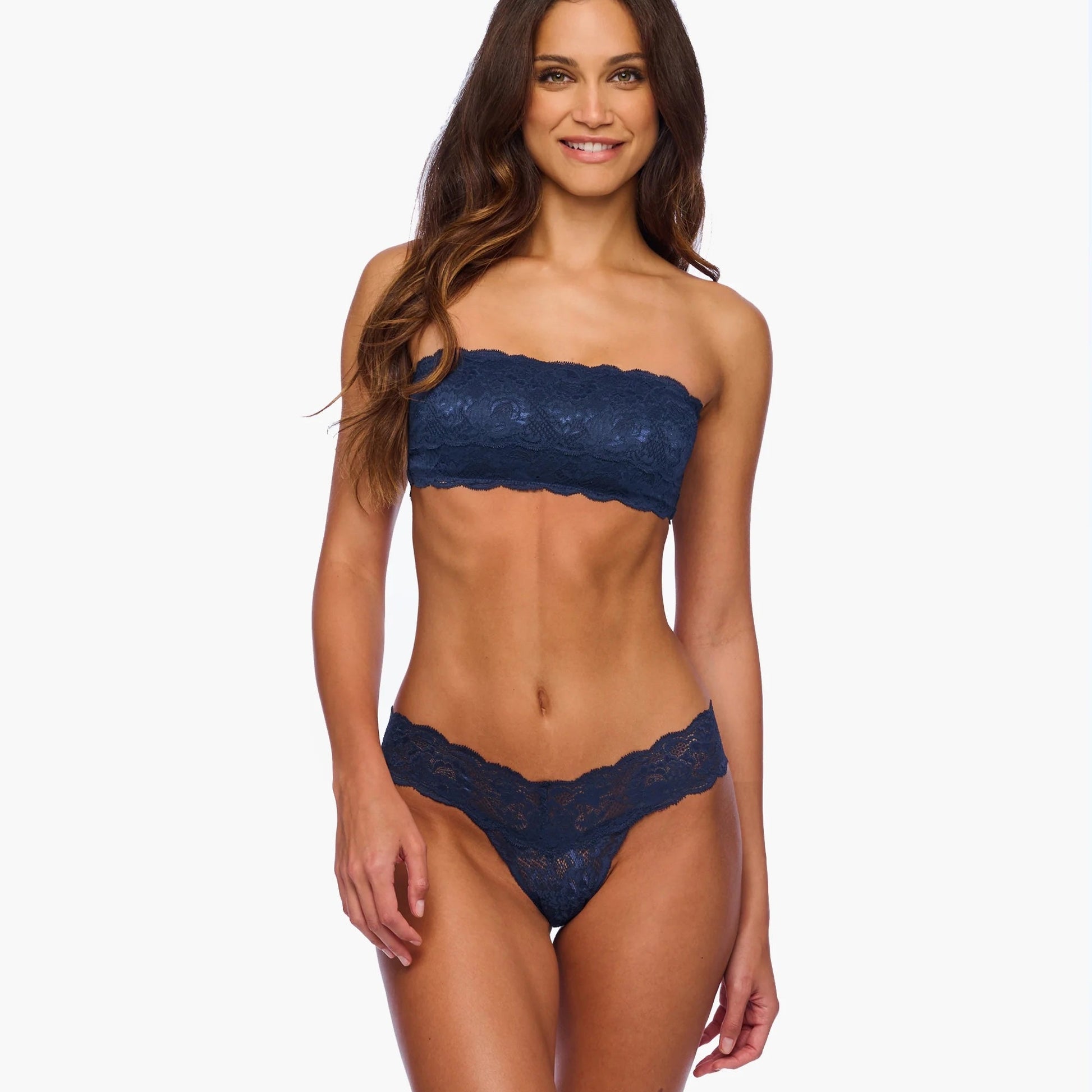 Woman wearing a navy blue lace bandeau bikini on a white background