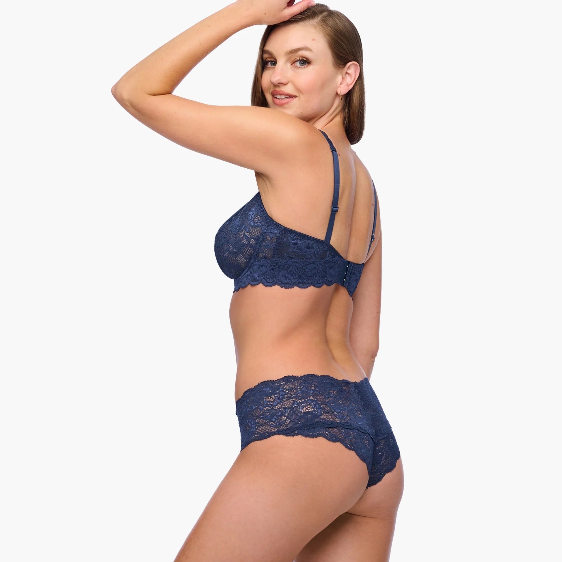 Woman wearing a navy blue lace lingerie set on a white background