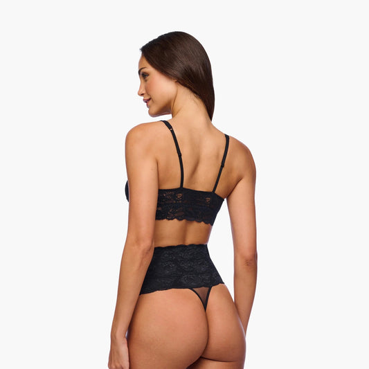 Woman wearing a black lace lingerie set on a white background