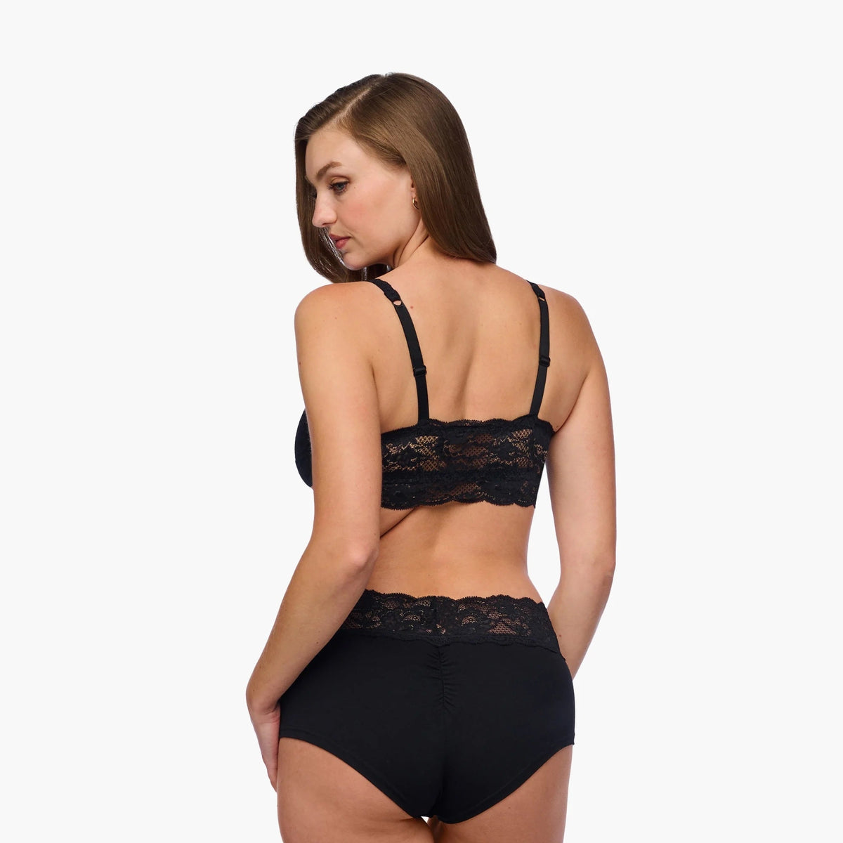 Woman wearing a black lace lingerie set on a white background