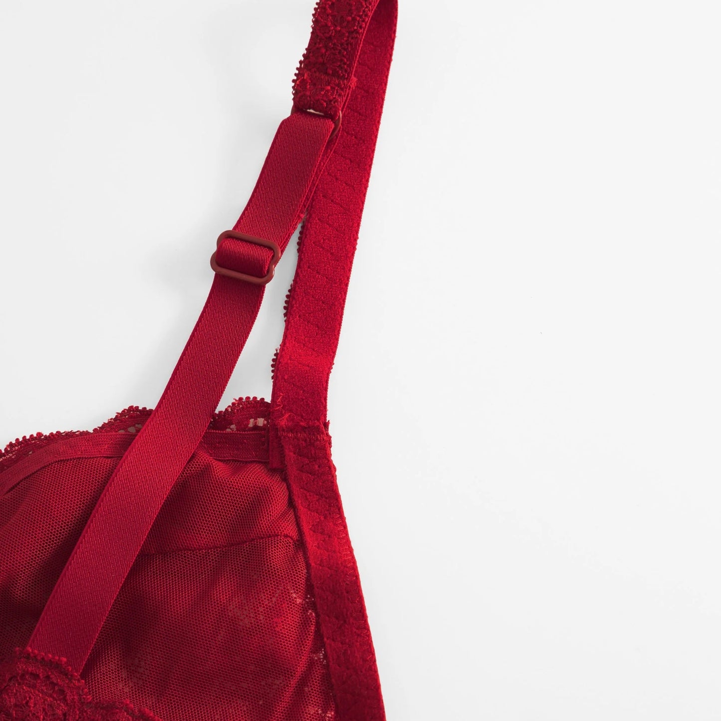 Red lace bra with a strap on a white background