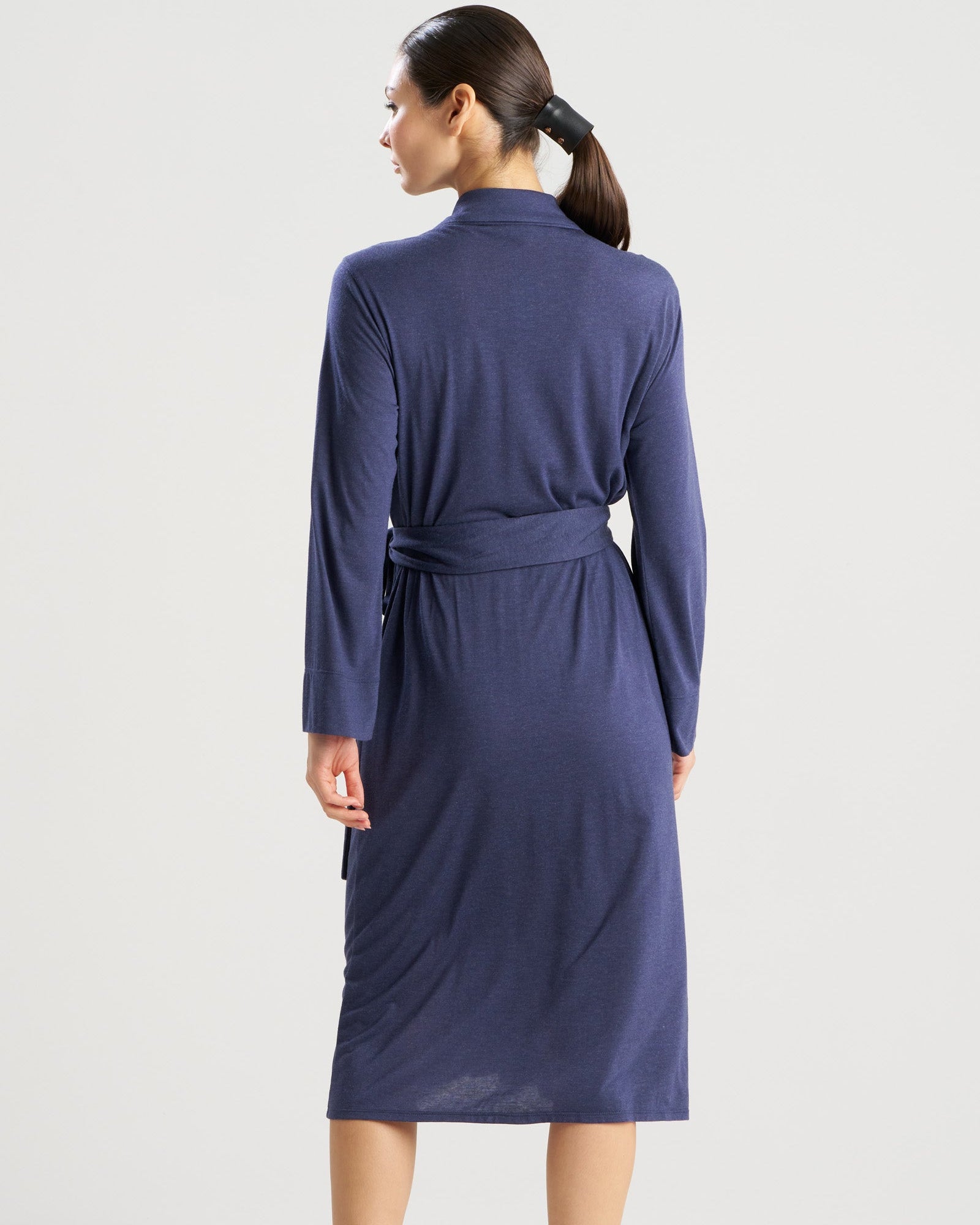 Woman wearing a blue robe with a belt on a white background