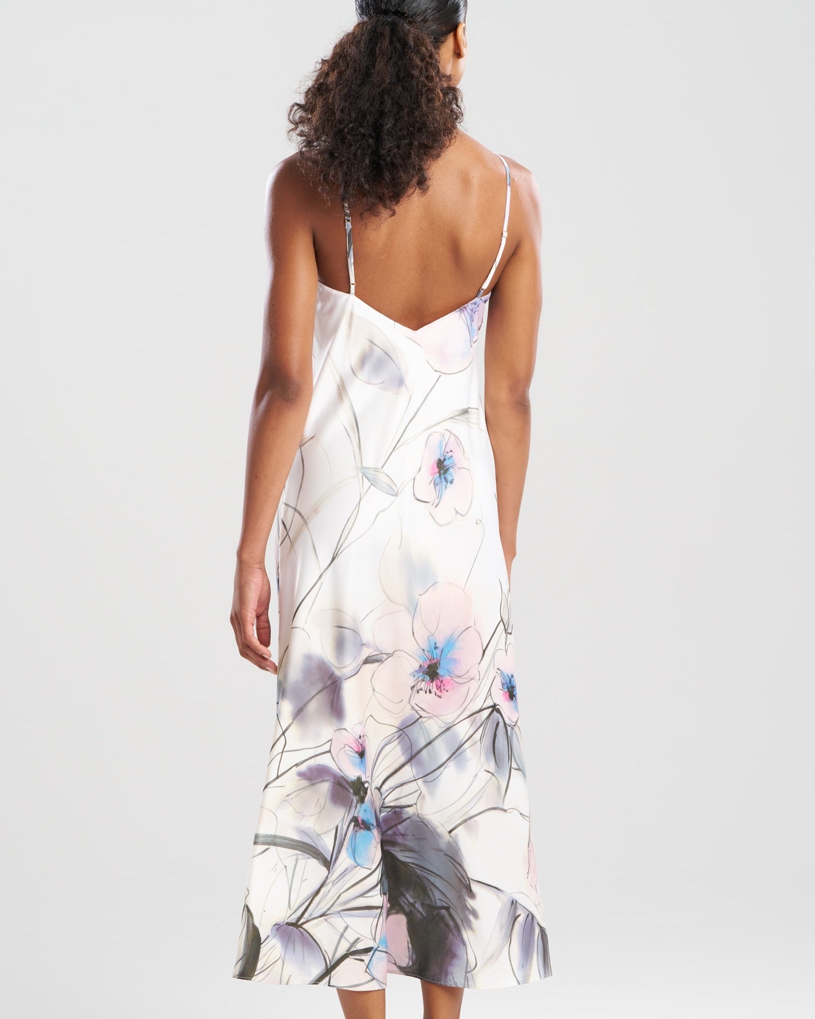Woman wearing a floral slip dress on a white background